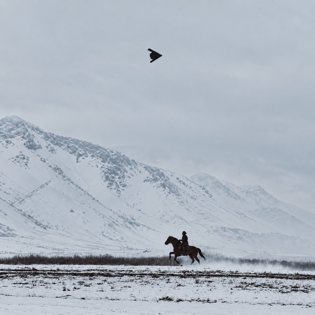 A rider crossing a snowy landscape beneath mountain peaks, symbolizing how technology carries humanity forward